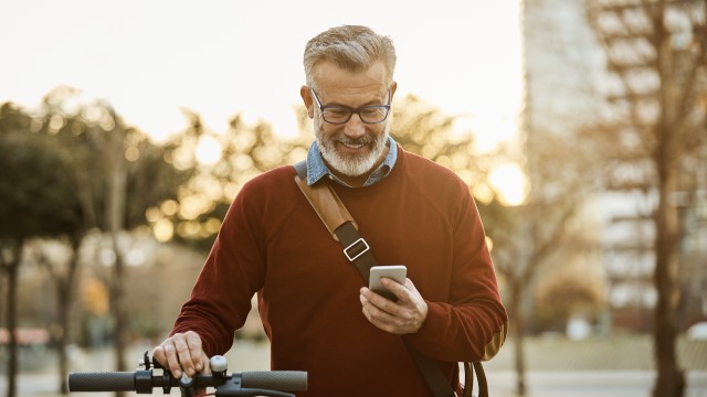 Mann på sykkel sjekker mobilen